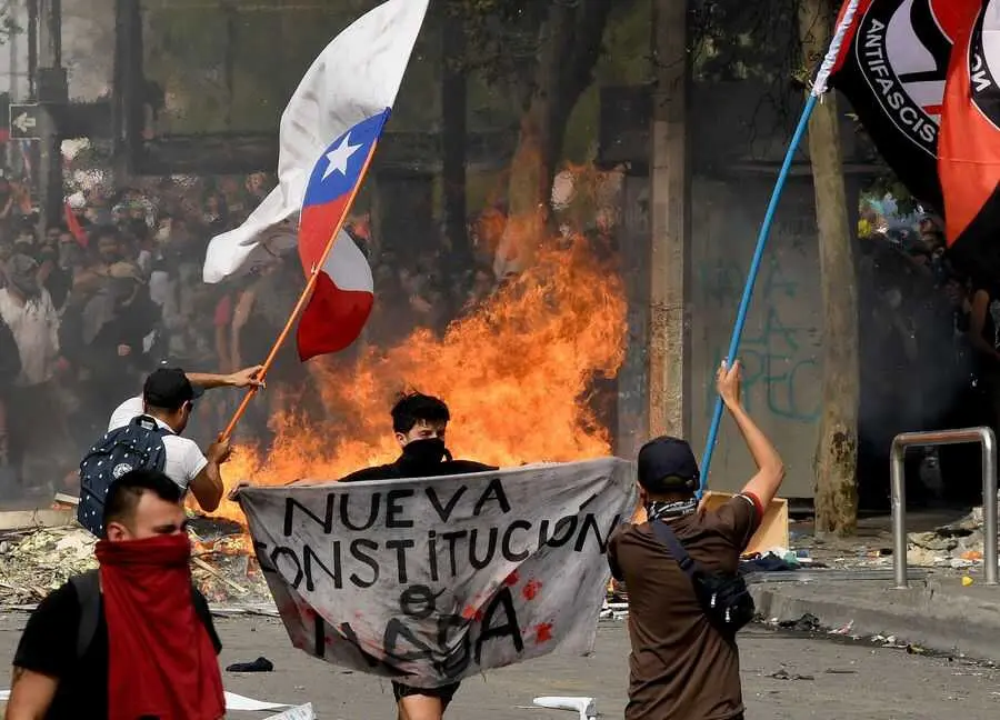  Manifestantes durante las protestas en contra del alza de los precios del transporte p&uacute;blico se movilizan en Santiago, 22 de octubre de 2019 &ndash; Xinhua / Jorge Villegas 