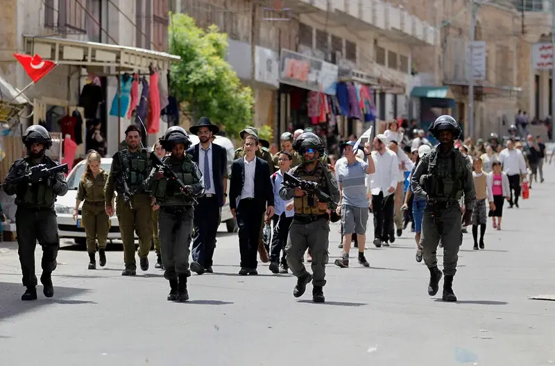 El 26 de abril de 2016 las tropas israel&iacute;es escoltan a colonos jud&iacute;os durante una visita a la ciudad cisjordana de Hebr&oacute;n con motivo de la festividad de la Pascua jud&iacute;a para que estos puedan disfrutar de sus derechos individuales garantizados por el Estado liberal de Israel - Wisam Hashlamoun / APA Images.