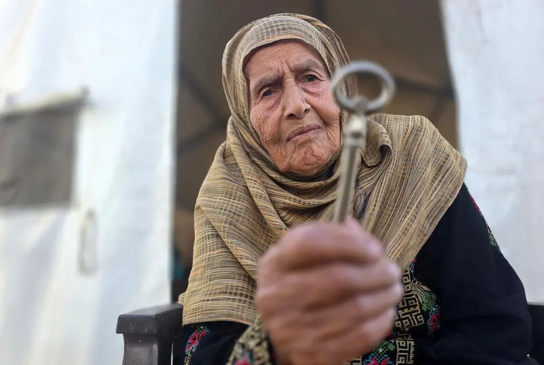 Reina Barhoum, de 91 a&ntilde;os, muestra las llaves de su casa de Bir al-Saba, de la que tuvo que huir durante la Nakba de 1948 para instalarse en Rafah, en el interior de su tienda de campa&ntilde;a en al-Mawasi, en Jan Younis, al sur de Gaza, de donde ha tenido que huir de nuevo a causa de los ataques israel&iacute;es - Tariq Mohammad / APA Images.