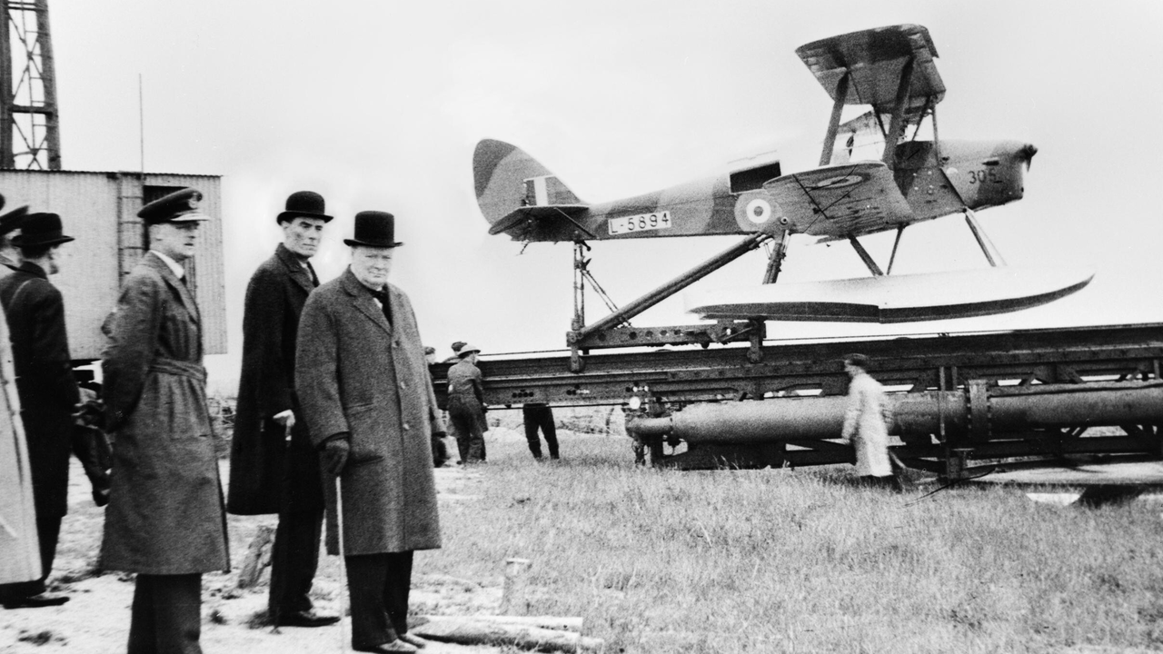 <p>Winston_Churchill y el Ministro de Guerra esperando el lanzamiento de un dron teledirigido por radio Havilland Queen Bee, 6 de junio de 1941._H10307. Wikimedia Commons</p>

