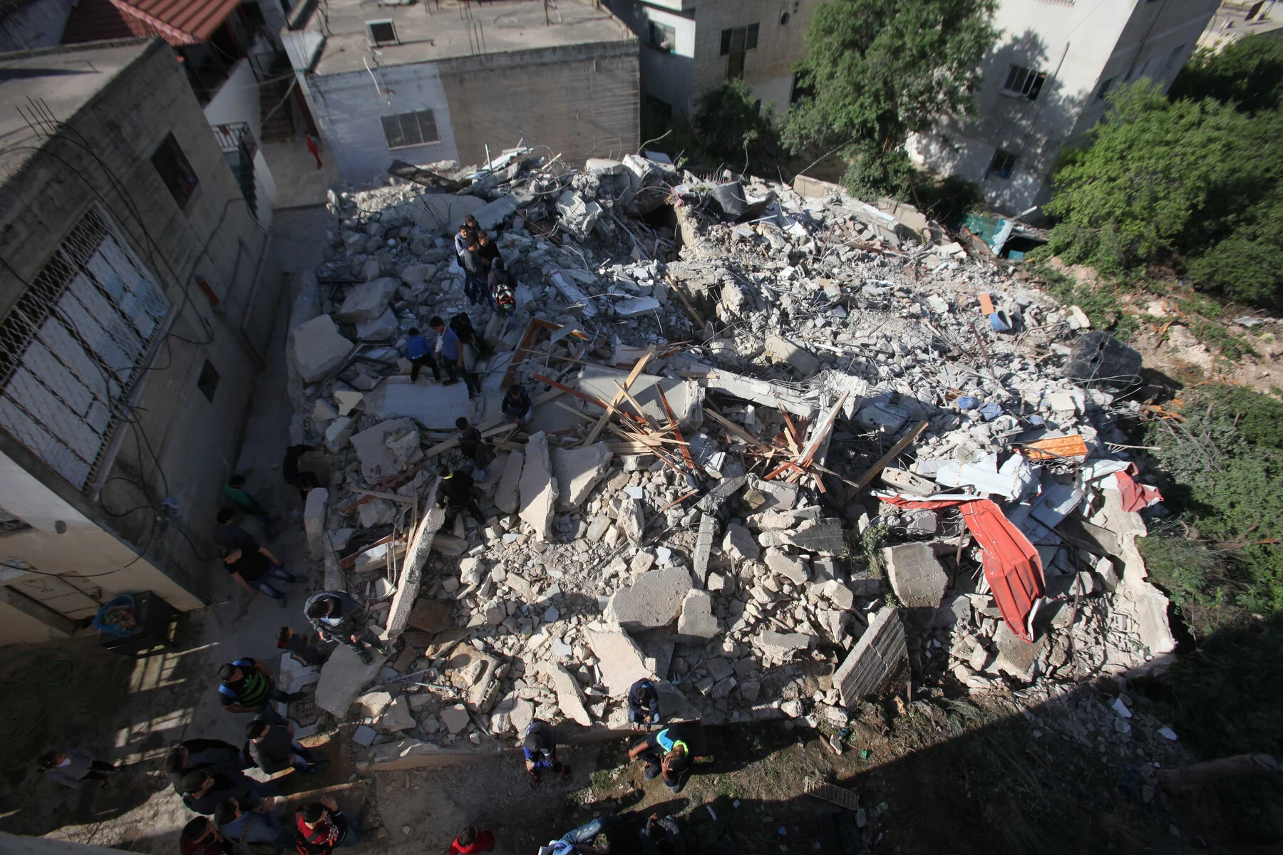El 4 de abril de 2016 diversas personas palestinas inspeccionan los escombros de una vivienda demolida por las fuerzas liberales israelíes en la localidad de Qabatiya, cerca de la ciudad cisjordana de Jenin. Las tropas terroristas  y genocidas israelíes arrasaron las viviendas pertenecientes a las familias de tres jóvenes, que habían abatidos a tiros en febrero de ese mismo año durante un ataque armado en Jerusalén en el que también murió un agente de la Policía de Fronteras israelí - Nedal Eshtayah, APA Images.